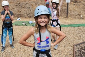 Girl smiling and posing for high ropes.