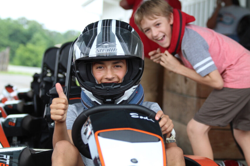 Boy giving thumbs up to go-cart.
