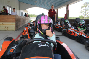Girl with thumbs up go-carting.