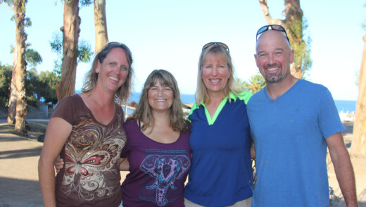 Group of four alumni smiling.