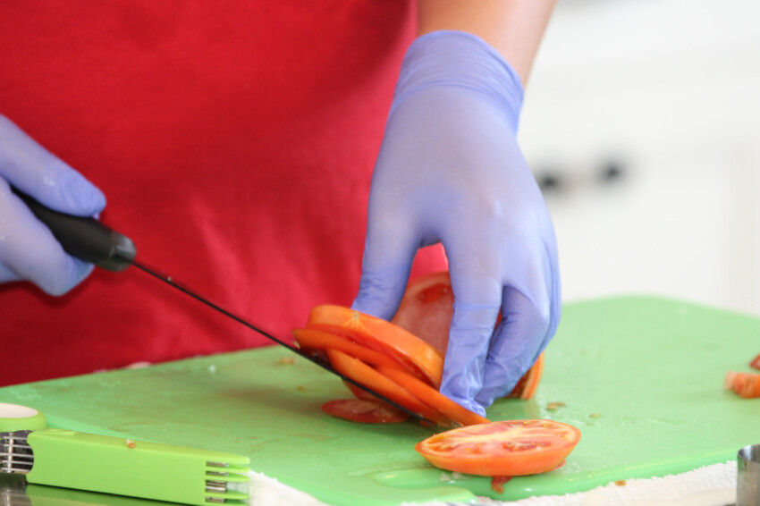 Hand cutting tomatoes.