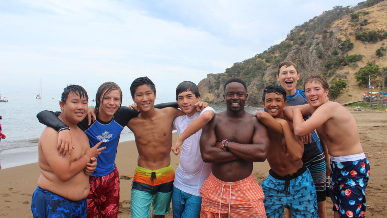 Kids posing on beach in bathing suits.