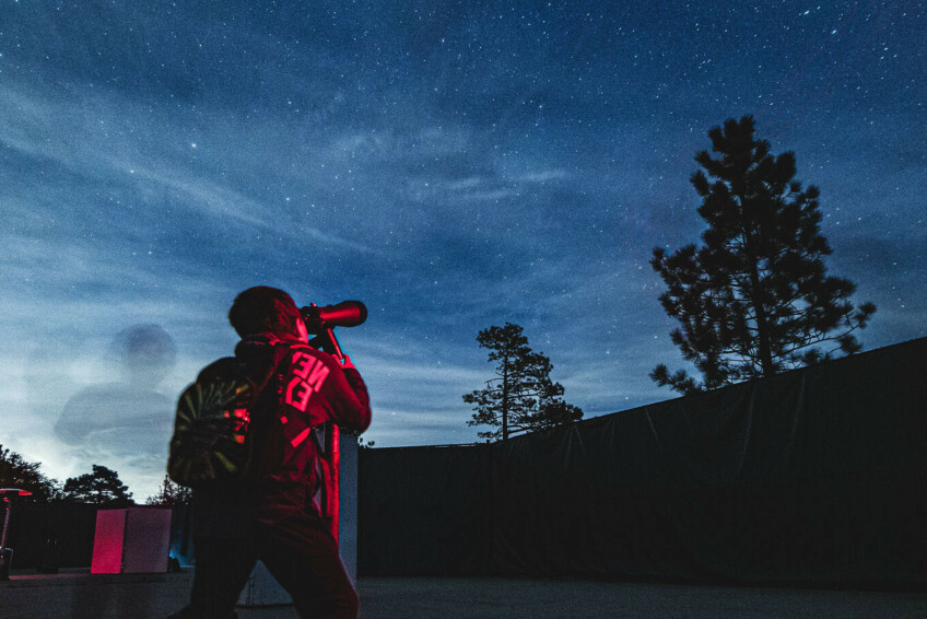 Person looking through telescope.