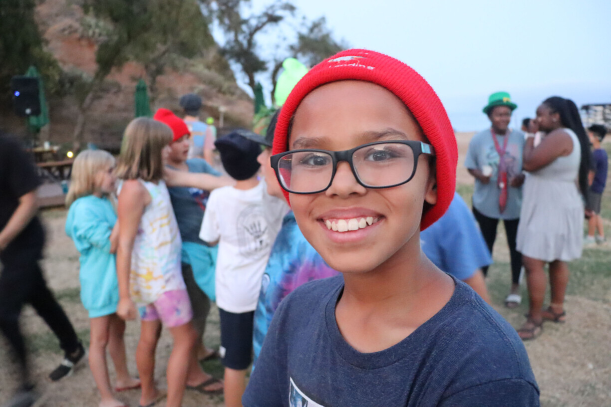 Boy with glasses in beanie smiling.