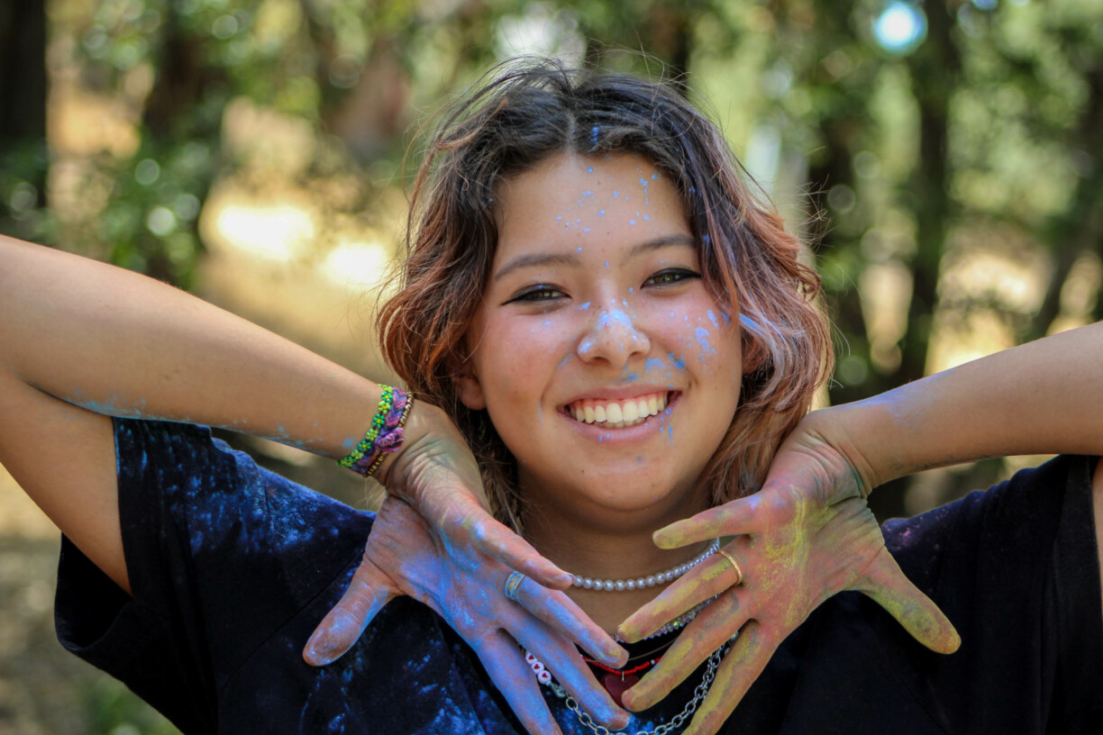 Girl smiling with paint on her.
